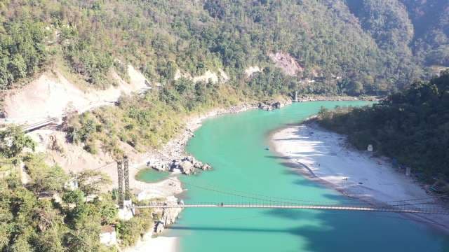Stunning Aerial View of Suspension Bridge Over Turquoise River