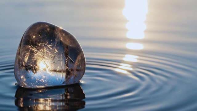 Polished Crystal Stone in Rippling Water at Sunset
