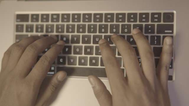 Close Up Top Down View of Hands Typing on Laptop Keyboard