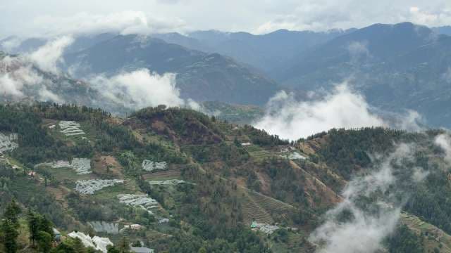 Mist Rolling Over Terraced Mountain Slopes and Lush Valleys