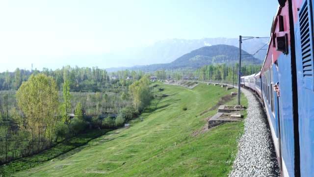 Scenic Train Journey Through Lush Green Mountain Valley