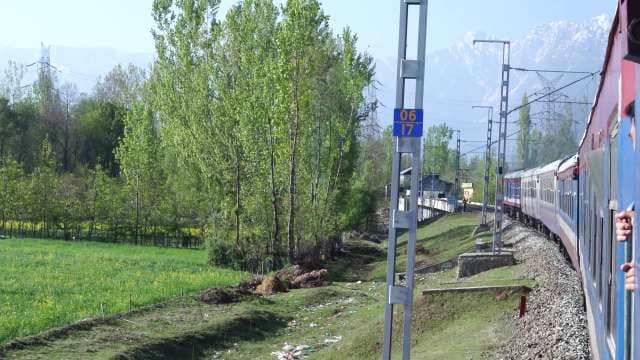 Passenger Train Traveling Through Scenic Kashmir Valley Mountains
