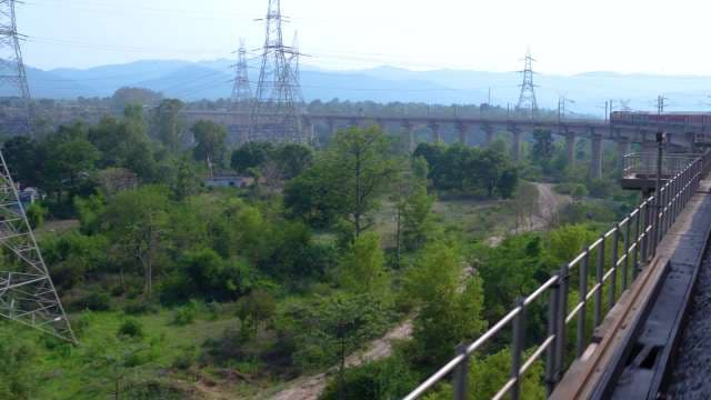 Train Crossing Elevated Bridge Through Scenic Rural Mountains