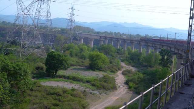 Indian Passenger Train Crossing Scenic Viaduct Bridge in Mountainous Landscape