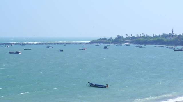 Traditional Fishing Boats Floating on Calm Turquoise Sea Near Lighthouse Coast